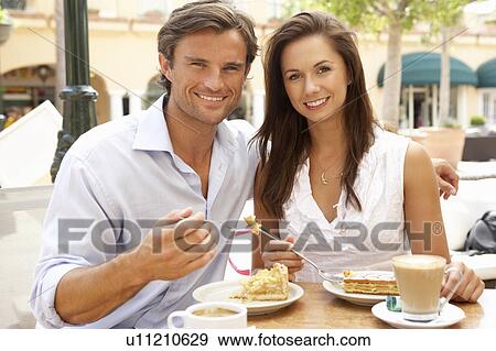 Young Couple Enjoying Coffee And Cake In Café View Large Photo Image Stock Photo - Young Couple Enjoying Coffee And Cake In Café. Fotosearch