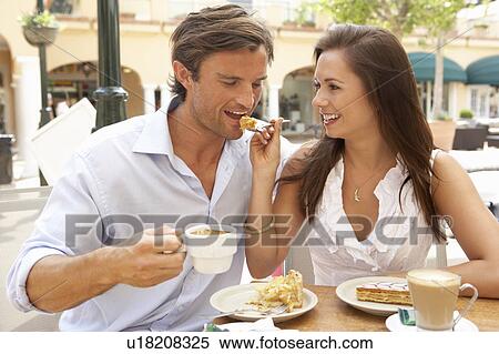 Stock Photography - Young Couple Enjoying Coffee And Cake In Café. Fotosearch