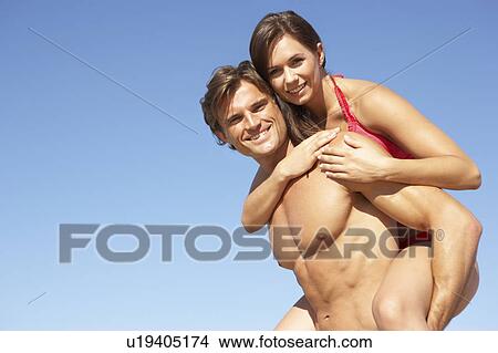 Young Couple Enjoying Piggyback On Beach Holiday View Large Photo Image Picture - Young Couple Enjoying Piggyback On Beach Holiday. Fotosearch