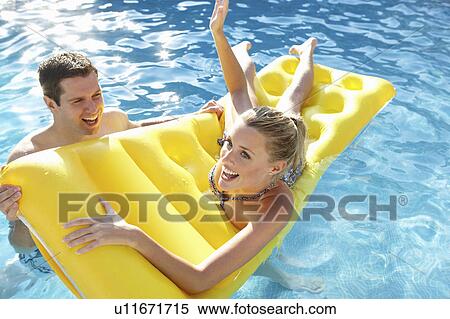 Young couple having fun in pool View Large Photo Image Stock Photography - Young couple having fun in pool. Fotosearch