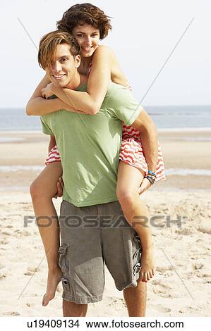 Young Couple Having Piggyback Fun On Beach View Large Photo Image Picture - Young Couple Having Piggyback Fun On Beach . Fotosearch