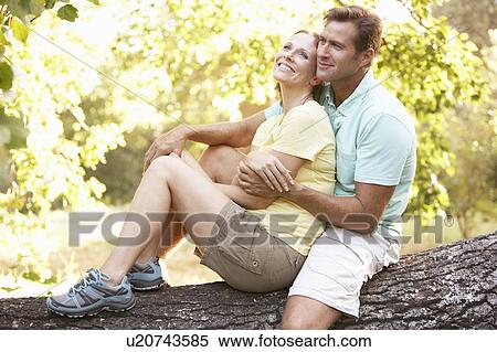 Young Couple In Walking Clothes Resting On Tree In Park View Large Photo Image Stock Photography - Young Couple In Walking Clothes Resting On Tree In Park. Fotosearch