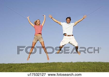 Young couple jumping in air View Large Photo Image Stock Photo - Young couple jumping in air. Fotosearch