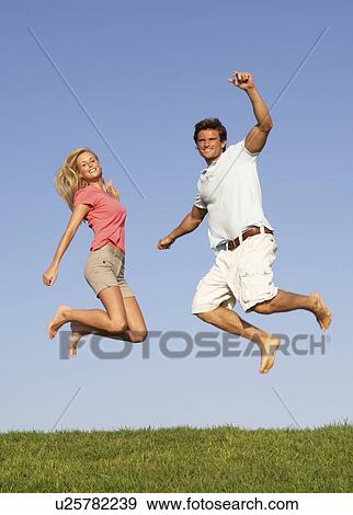 Stock Photo - Young couple jumping in air. Fotosearch