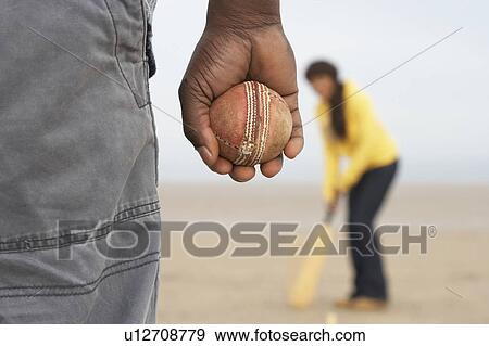 Stock Photo - Young Couple Playing Cricket On Autumn Beach Holiday. Fotosearch