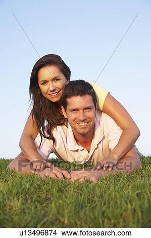 Picture - Young couple posing on a field. Fotosearch