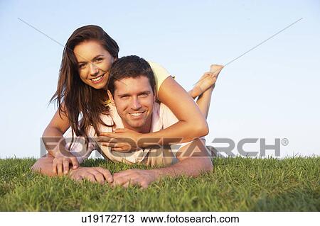 Stock Image - Young couple posing on a field. Fotosearch