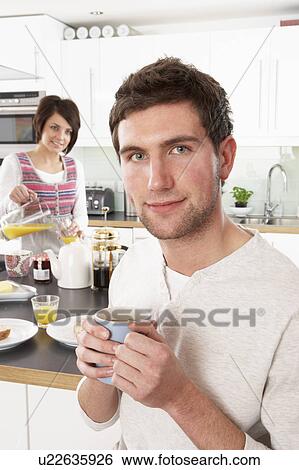 Young Couple Preparing Breakfast In Modern Kitchen View Large Photo Image Stock Photograph - Young Couple Preparing Breakfast In Modern Kitchen . Fotosearch