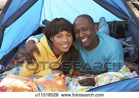 Stock Photo - Young Couple Relaxing Inside Tent On Camping Holiday. Fotosearch