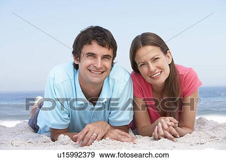 Stock Photo - Young Couple Relaxing On Beach. Fotosearch