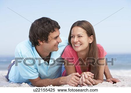 Stock Photography - Young Couple Relaxing On Beach. Fotosearch