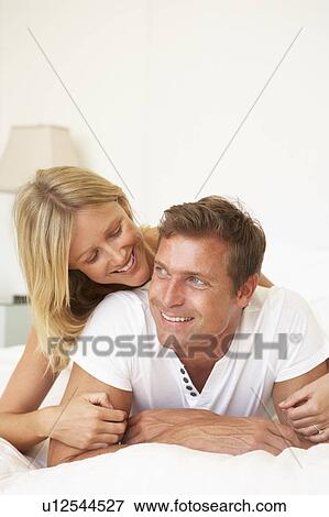 Stock Photo - Young Couple Relaxing On Bed. Fotosearch