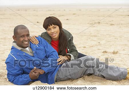 Picture - Young Couple Relaxing On Winter Beach Holiday. Fotosearch