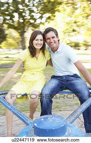 Young Couple Riding On Roundabout In Park View Large Photo Image Stock Photo - Young Couple Riding On Roundabout In Park. Fotosearch
