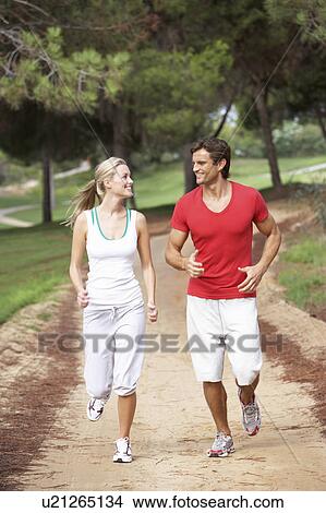 Picture - Young couple running in park. Fotosearch