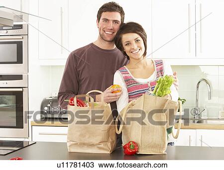 Young Couple Unpacking Shopping In Modern Kitchen View Large Photo Image Stock Image - Young Couple Unpacking Shopping In Modern Kitchen . Fotosearch