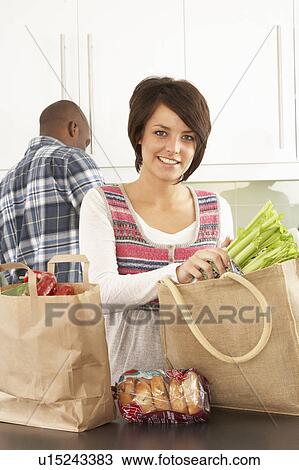 Young Couple Unpacking Shopping In Modern Kitchen View Large Photo Image Stock Image - Young Couple Unpacking Shopping In Modern Kitchen . Fotosearch