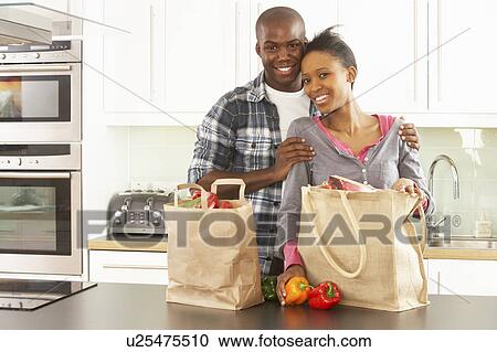 Young Couple Unpacking Shopping In Modern Kitchen View Large Photo Image Stock Image - Young Couple Unpacking Shopping In Modern Kitchen . Fotosearch