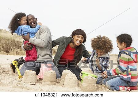 Young Family Building Sandcastle On Beach Holiday View Large Photo Image Stock Image - Young Family Building Sandcastle On Beach Holiday. Fotosearch