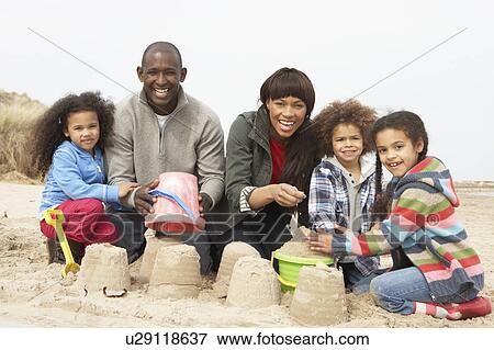 Young Family Building Sandcastle On Beach Holiday View Large Photo Image Stock Photo - Young Family Building Sandcastle On Beach Holiday. Fotosearch