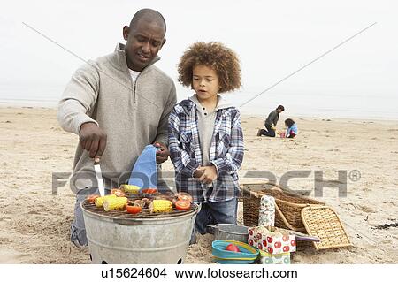 Young Family Enjoying Barbeque On Beach View Large Photo Image Picture - Young Family Enjoying Barbeque On Beach. Fotosearch