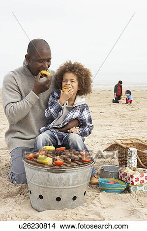Young Family Enjoying Barbeque On Beach View Large Photo Image Picture - Young Family Enjoying Barbeque On Beach. Fotosearch
