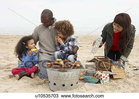 Young Family Enjoying Barbeque On Beach View Large Photo Image Stock Image - Young Family Enjoying Barbeque On Beach. Fotosearch