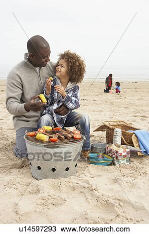 Young Family Enjoying Barbeque On Beach View Large Photo Image Stock Image - Young Family Enjoying Barbeque On Beach. Fotosearch