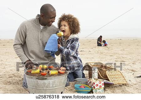 Young Family Enjoying Barbeque On Beach View Large Photo Image Stock Photo - Young Family Enjoying Barbeque On Beach. Fotosearch