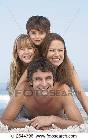 Stock Photograph - Young Family Having Fun On Beach Holiday. Fotosearch