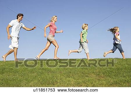 Young family, parents with children, running through field View Large Photo Image Stock Image - Young family, parents with children, running through field. Fotosearch