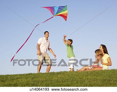 Young family, parents with children, playing in a field View Large Photo Image Stock Image - Young family, parents with children, playing in a field. Fotosearch