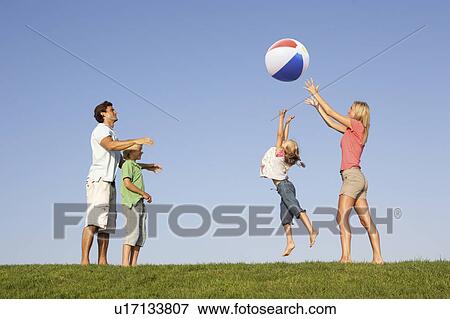 Young family, parents with children, playing in a field View Large Photo Image Stock Photo - Young family, parents with children, playing in a field. Fotosearch