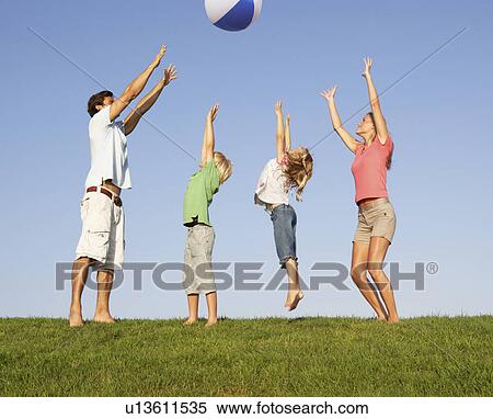 Stock Photography - Young family, parents with children, playing in a field. Fotosearch