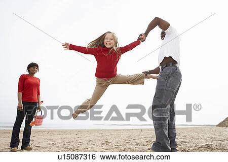 Stock Photograph - Young Family Relaxing On Beach Camping Holiday. Fotosearch