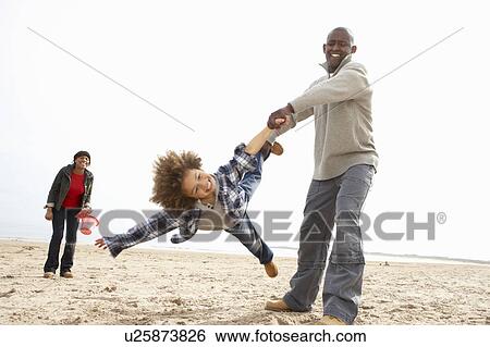 Stock Photograph - Young Family Relaxing On Beach Camping Holiday. Fotosearch