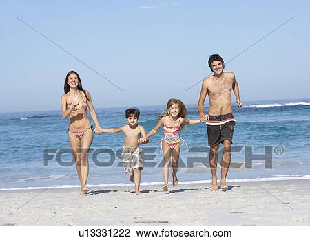 Young Family Running Along Beach on Holiday View Large Photo Image Stock Image - Young Family Running Along Beach on Holiday. Fotosearch