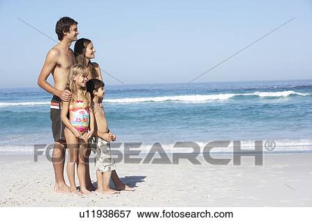 Young Family Standing On Sandy Beach on Holiday View Large Photo Image Stock Photo - Young Family Standing On Sandy Beach on Holiday. Fotosearch