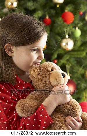 Young Girl Cuddling Teddy Bear In Front Of Christmas Tree View Large Photo Image Stock Image - Young Girl Cuddling Teddy Bear In Front Of Christmas Tree. Fotosearch