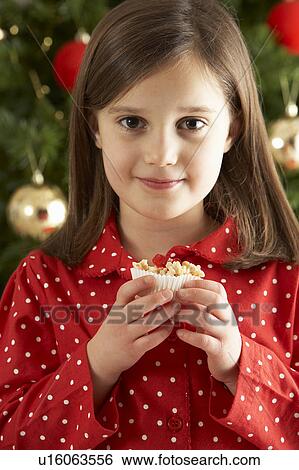 Young Girl Eating Christmas Cake In Front Of Christmas Tree View Large Photo Image Stock Photograph - Young Girl Eating Christmas Cake In Front Of Christmas Tree. Fotosearch