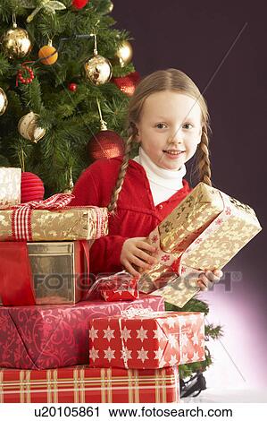 Young Girl Holding Christmas Present In Front Of Christmas Tree View Large Photo Image Stock Image - Young Girl Holding Christmas Present In Front Of Christmas Tree. Fotosearch