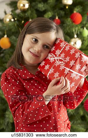Young Girl Holding Gift In Front Of Christmas Tree View Large Photo Image Stock Image - Young Girl Holding Gift In Front Of Christmas Tree. Fotosearch