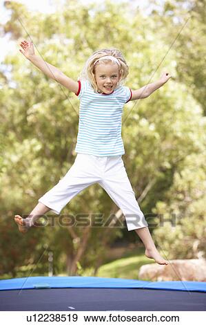 Young Girl Jumping On Trampoline In Garden View Large Photo Image Stock Photo - Young Girl Jumping On Trampoline In Garden. Fotosearch