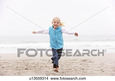 Young Girl On Holiday Running Along Winter Beach View Large Photo Image Picture - Young Girl On Holiday Running Along Winter Beach. Fotosearch
