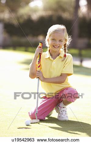Stock Image - Young Girl Practising Golf On Putting On Green. Fotosearch