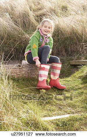 Young Girl Putting On Wellington Boots View Large Photo Image Stock Photo - Young Girl Putting On Wellington Boots. Fotosearch