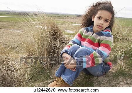 Young Girl Sitting Amongst Dunes On Winter Beach View Large Photo Image Stock Image - Young Girl Sitting Amongst Dunes On Winter Beach. Fotosearch