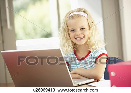 Stock Image - Young Girl Using Laptop At Home. Fotosearch