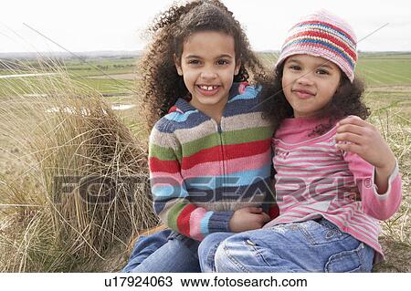 Young Girls Sitting Amongst Dunes On Winter Beach View Large Photo Image Stock Image - Young Girls Sitting Amongst Dunes On Winter Beach. Fotosearch