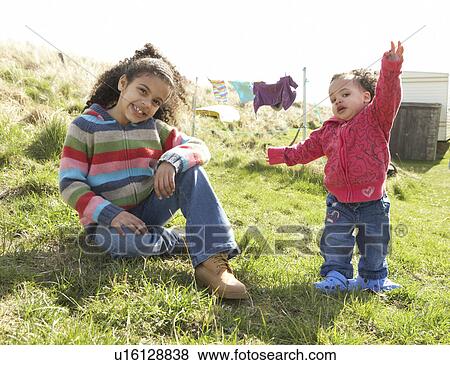 Stock Photo - Young Girls Sitting Outside In Caravan Park. Fotosearch